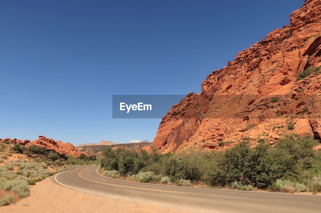 Landscape of road leading between red rock hills in snow canyon state park in utah