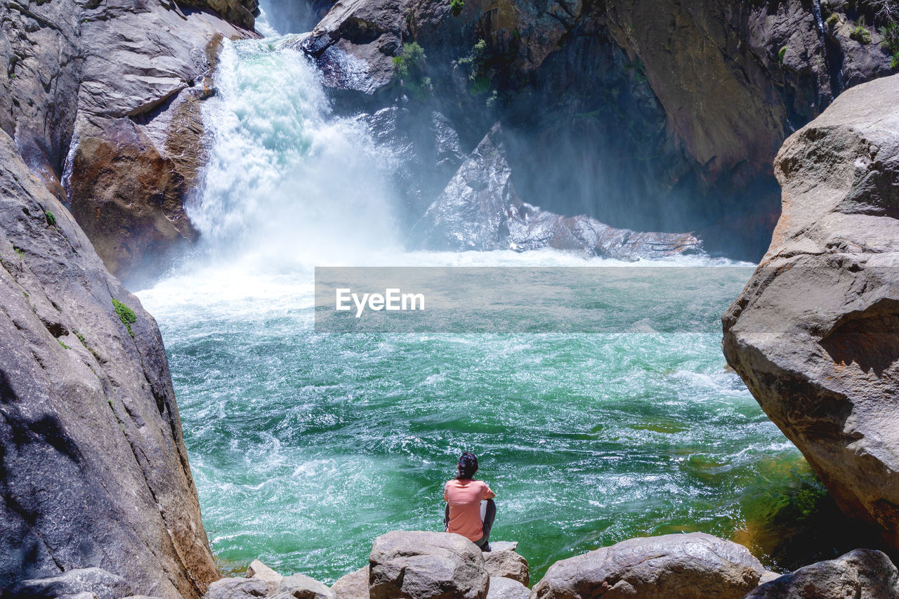 Scenic view of waterfall and a woman in the sequoia national park 