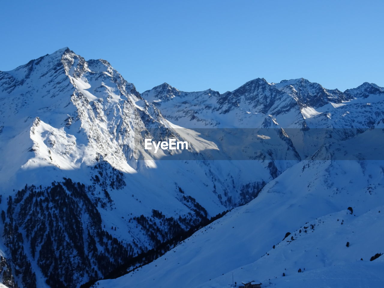 Scenic view of snow covered mountains against clear sky