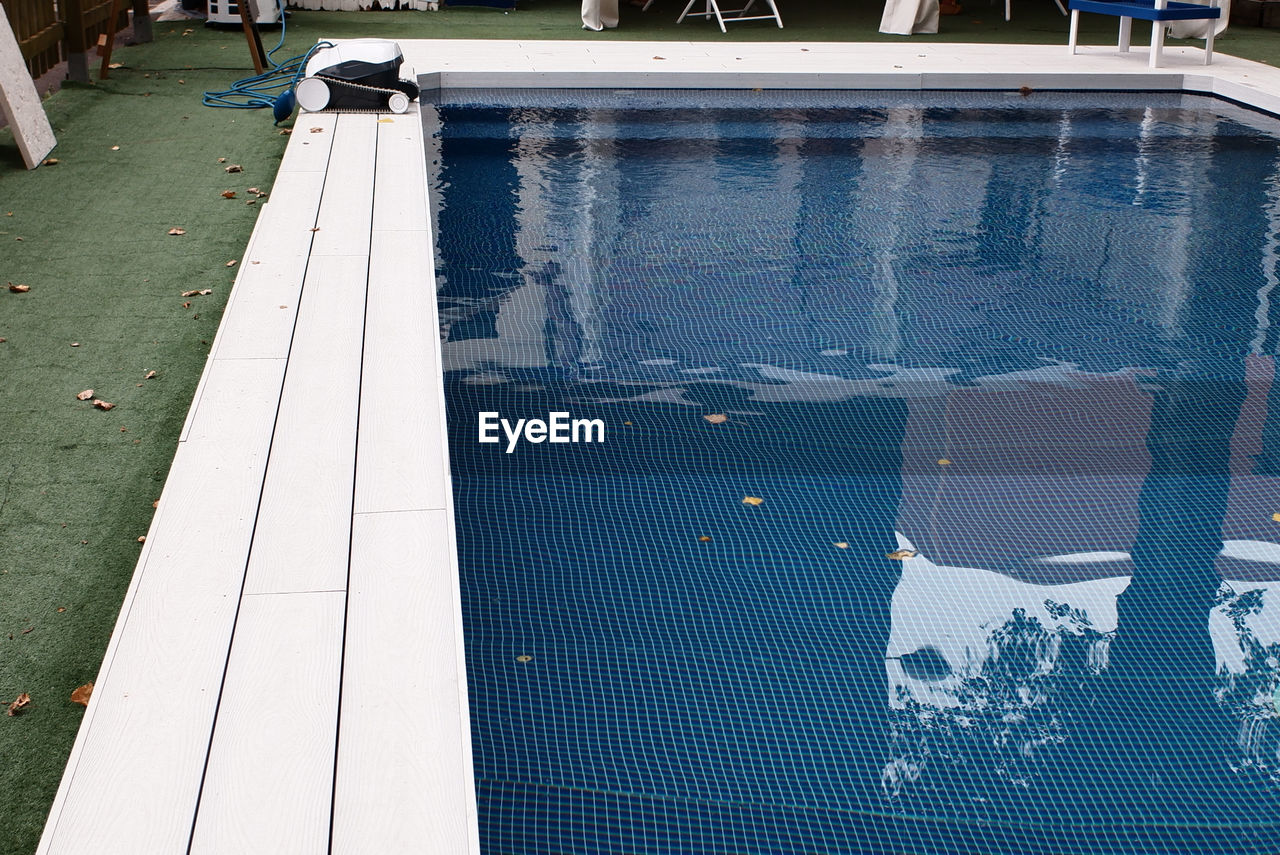 HIGH ANGLE VIEW OF PEOPLE SWIMMING POOL