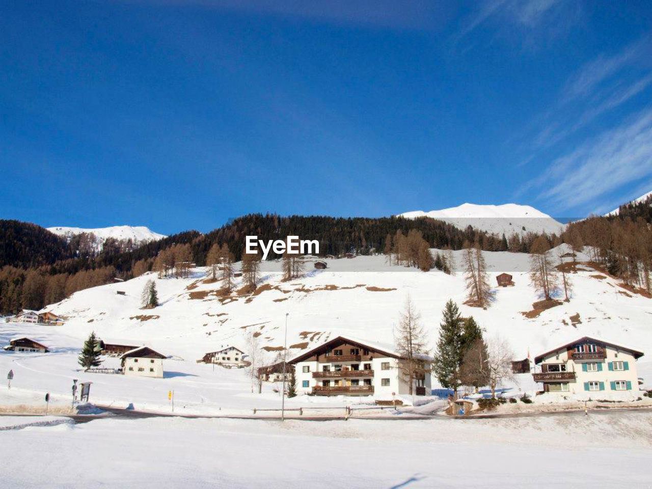 Houses on snowcapped mountains against sky