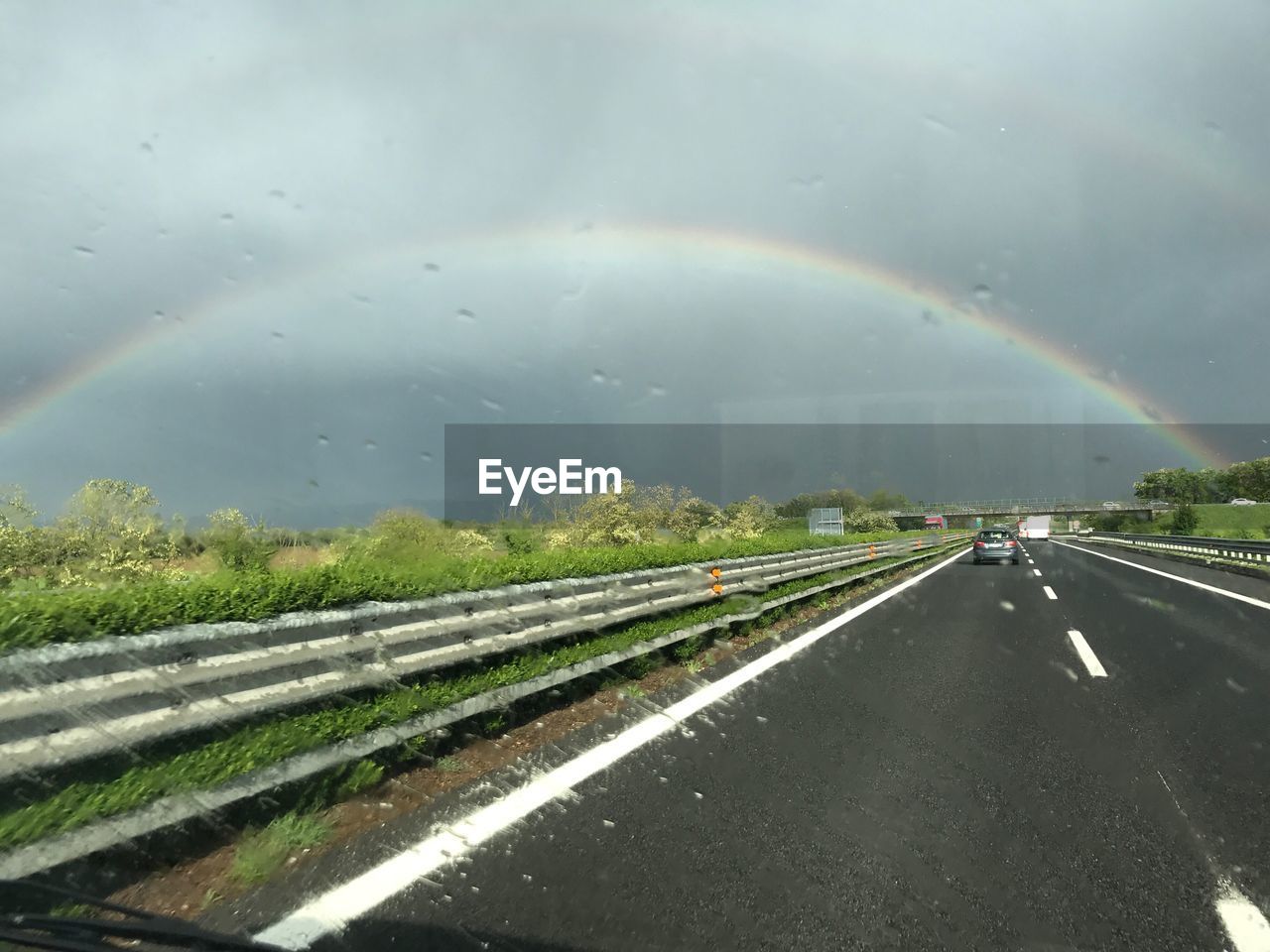 VIEW OF RAINBOW OVER ROAD AGAINST SKY