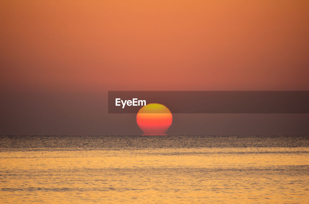 SCENIC VIEW OF SUNSET OVER SEA