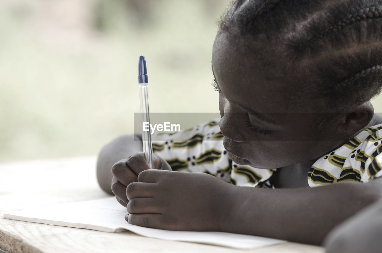 Close-up of girl writing in book