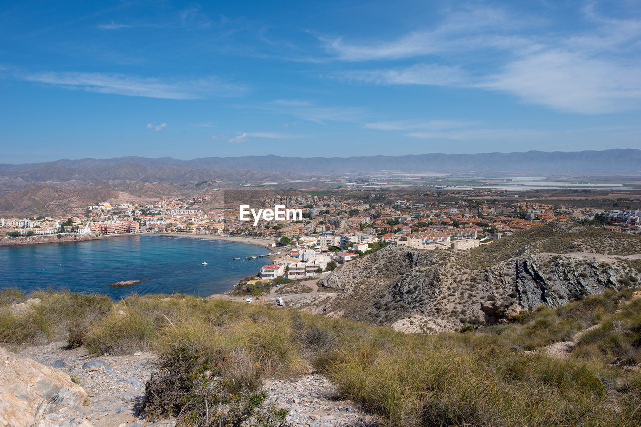 Scenic view of sea by buildings against sky