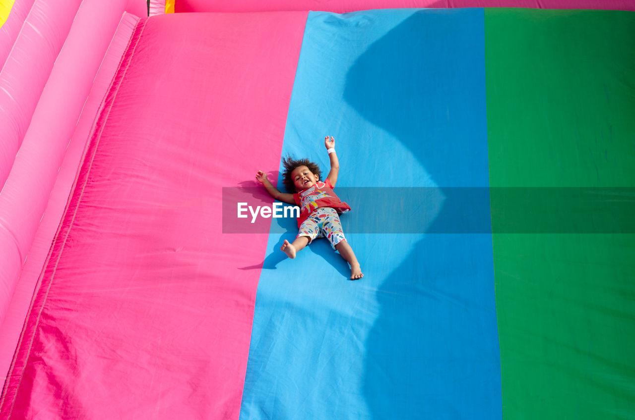 Chilf sliding down on a bouncy castle