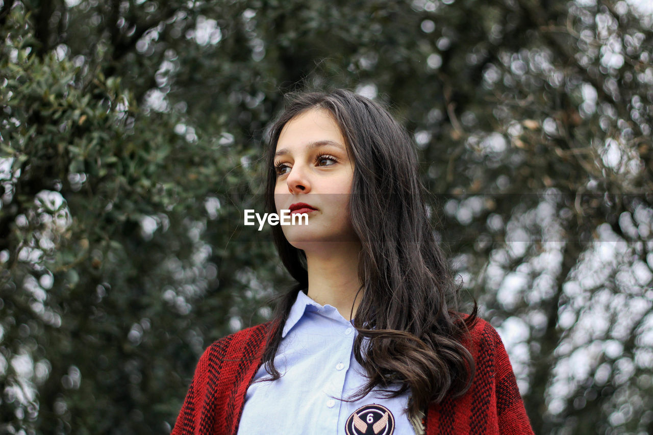 Young girl looking straight ahead in the forest