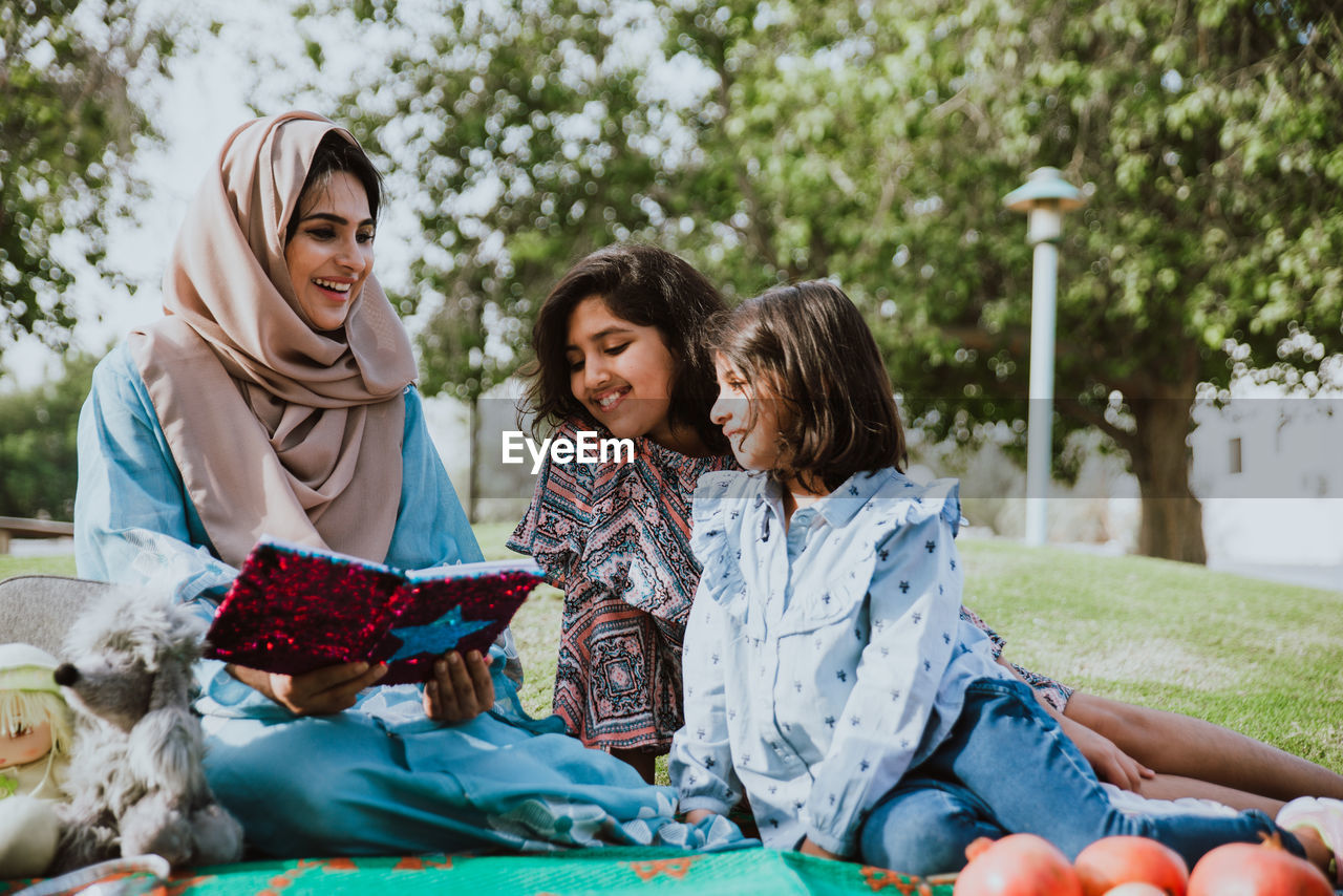 Mother with cheerful daughters enjoying at park