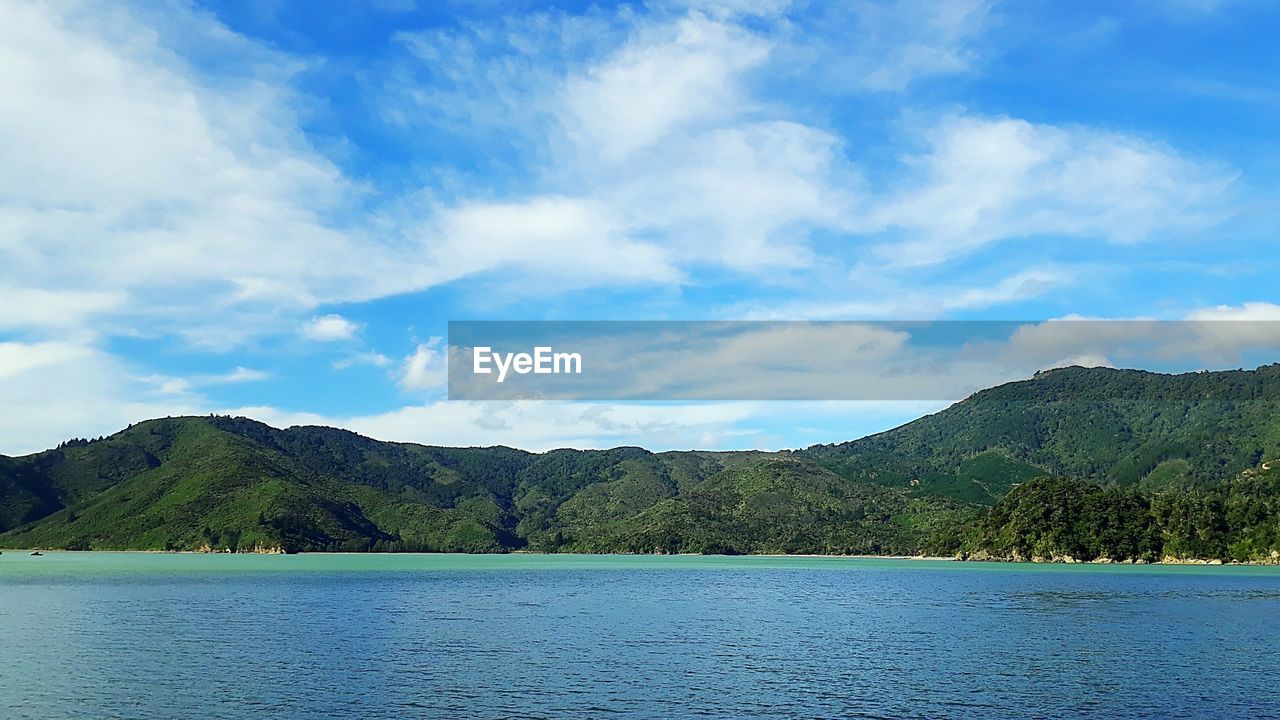 SCENIC VIEW OF LAKE BY MOUNTAIN AGAINST SKY