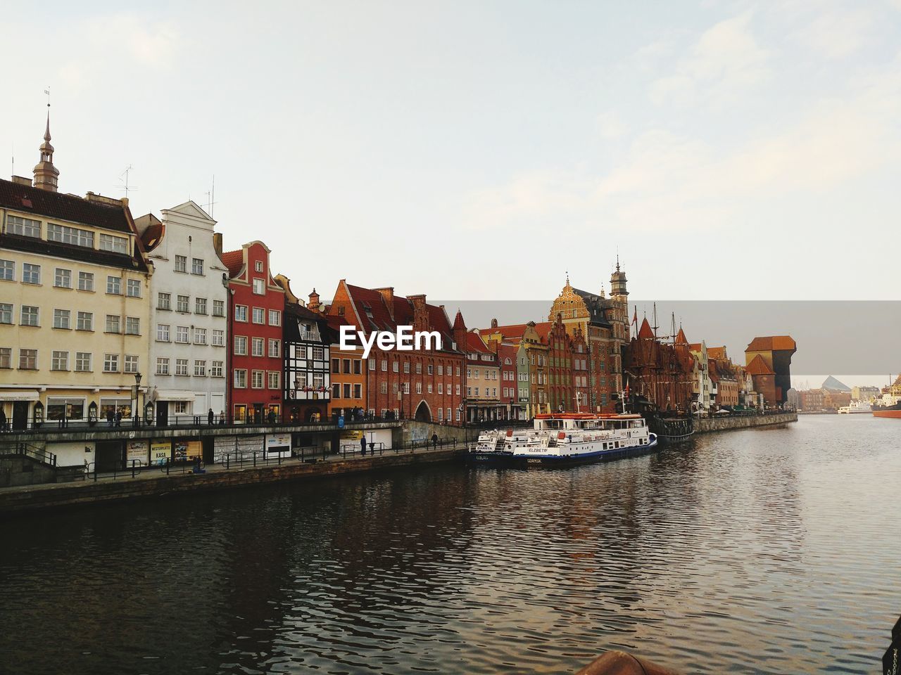 BOATS IN RIVER AGAINST SKY IN CITY