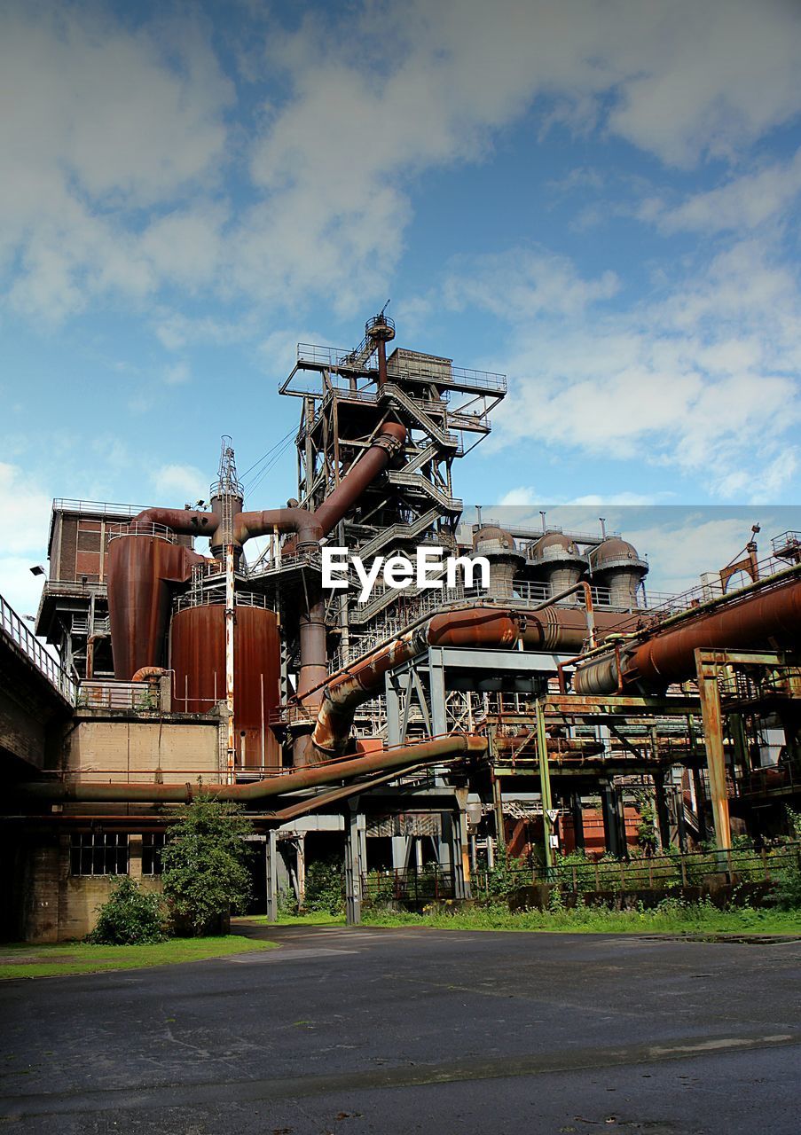 Exterior of rusty factory against sky