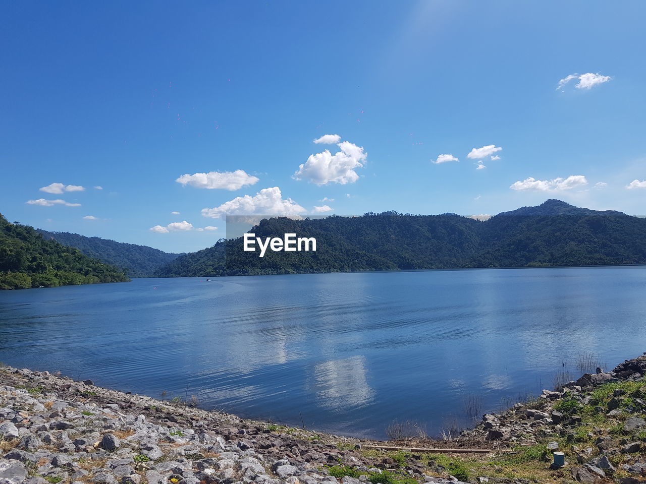 SCENIC VIEW OF LAKE BY MOUNTAINS AGAINST BLUE SKY
