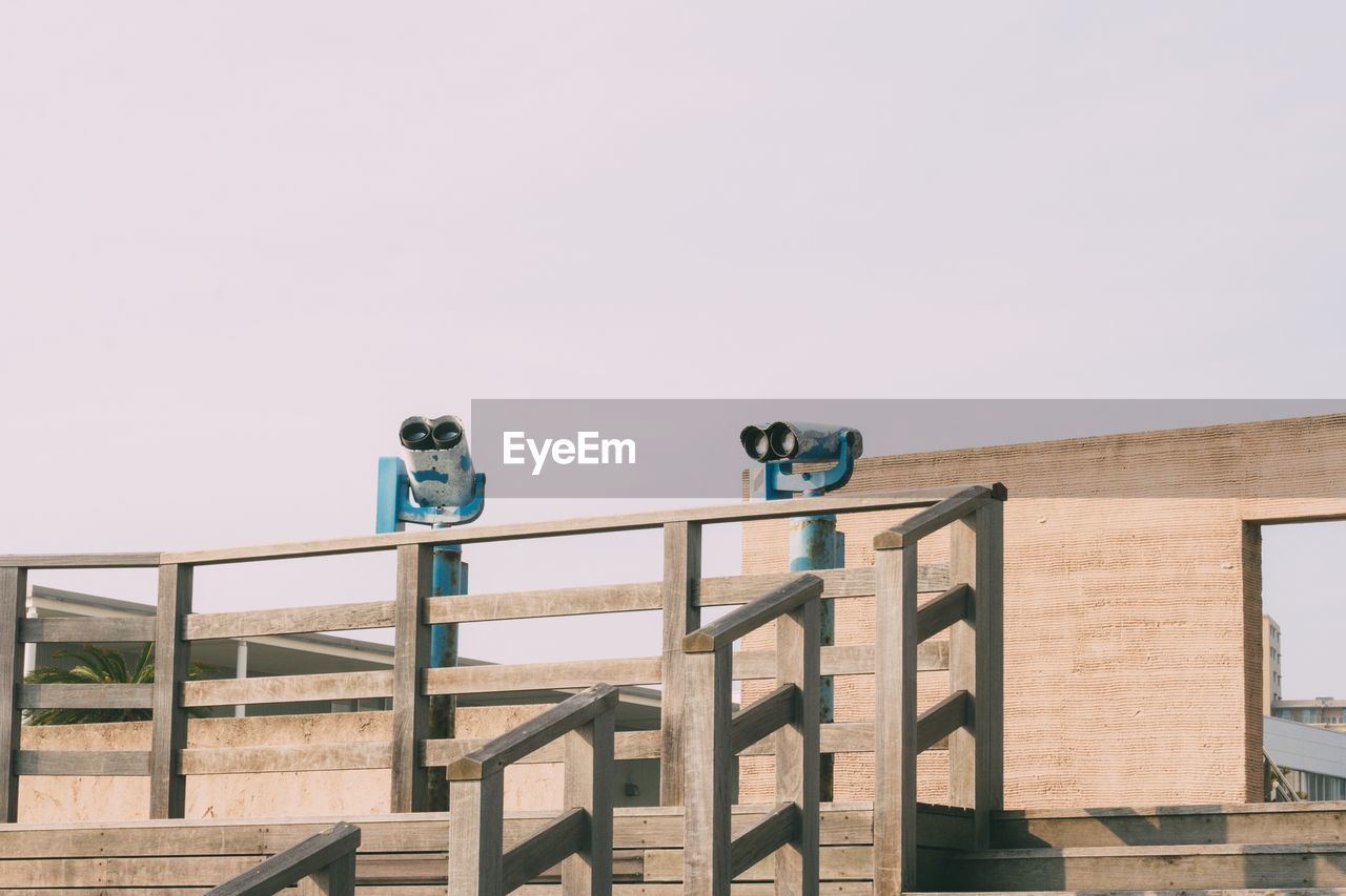 Low angle view of coin-operated binoculars against clear sky