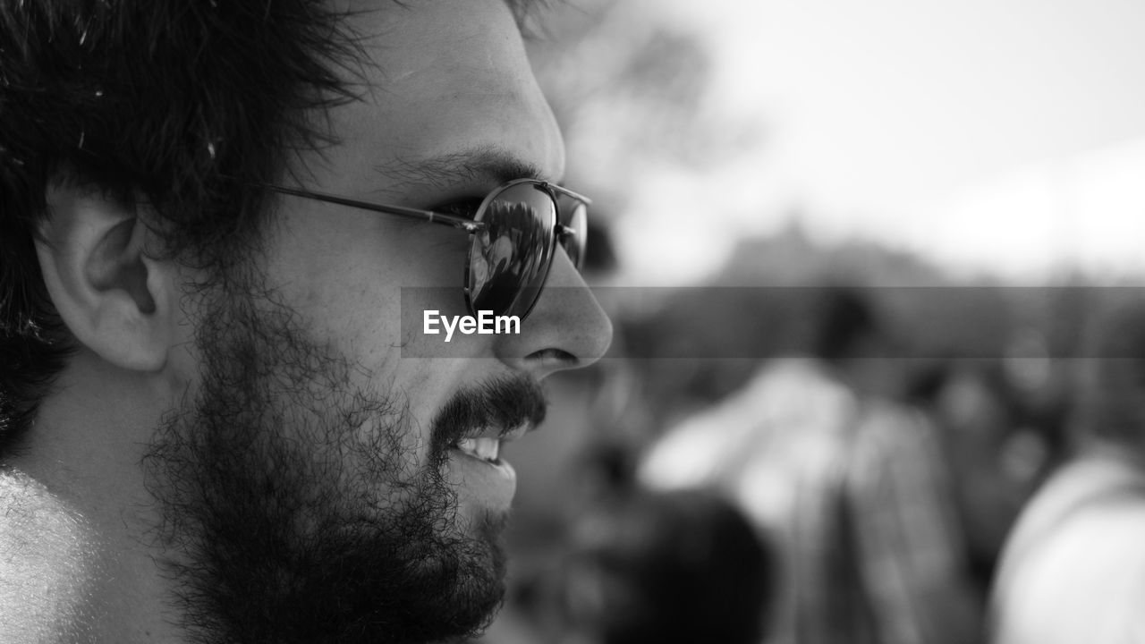 Close-up profile view of confident man with beard wearing sunglasses