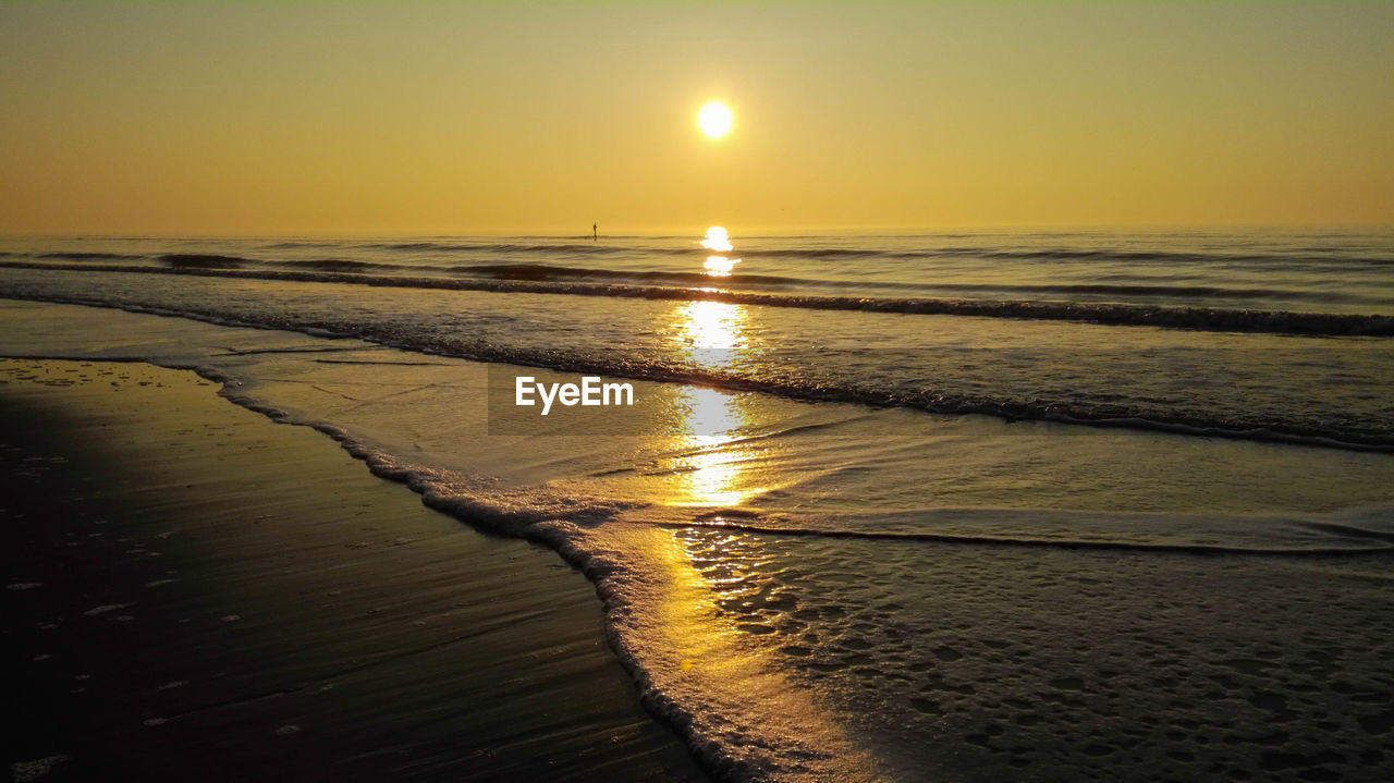 Scenic view of beach against sky during sunset