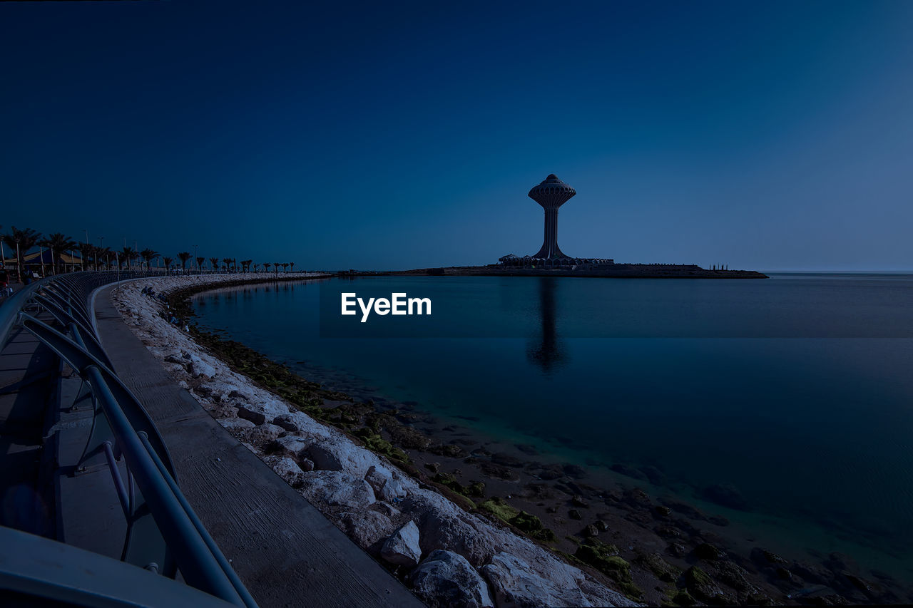 BRIDGE OVER SEA AGAINST CLEAR BLUE SKY AT NIGHT