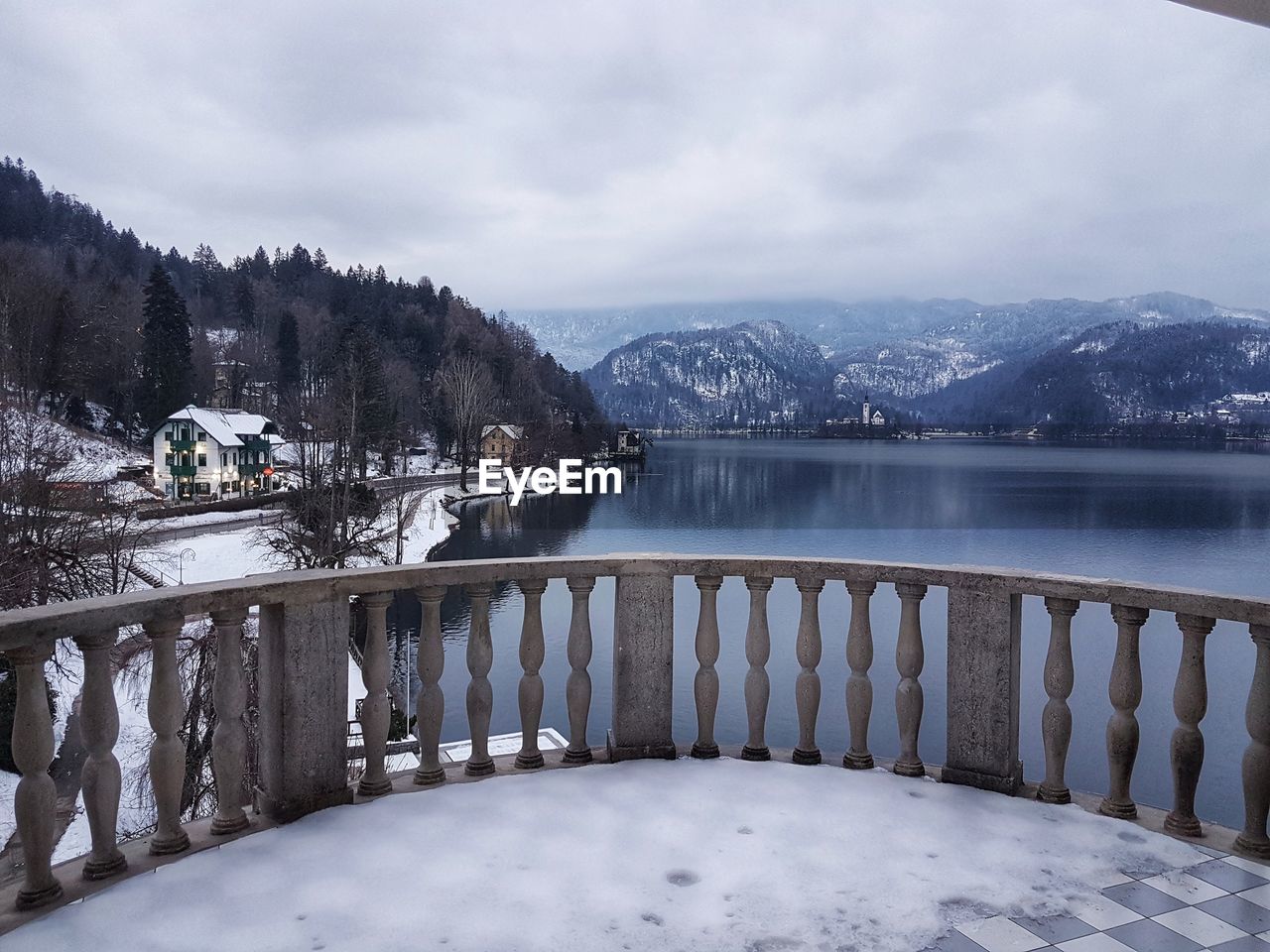 Scenic view of lake by snowcapped mountains against sky