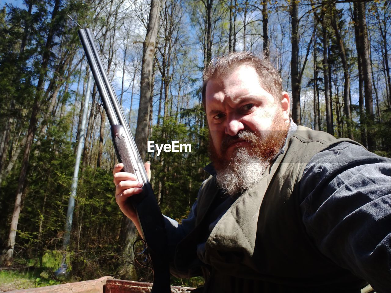 Portrait of senior man standing in forest