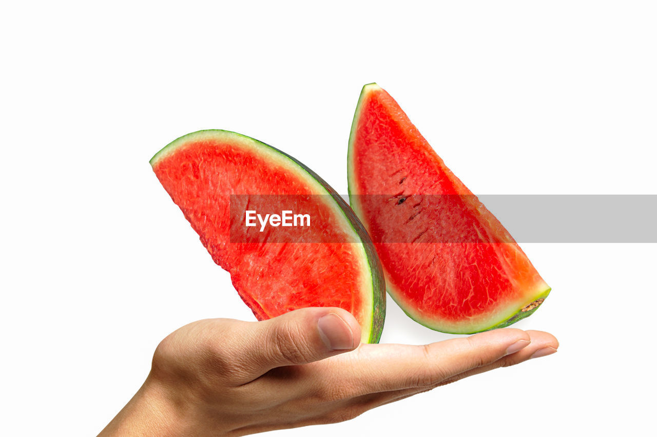 CROPPED IMAGE OF HAND HOLDING STRAWBERRY AGAINST WHITE BACKGROUND