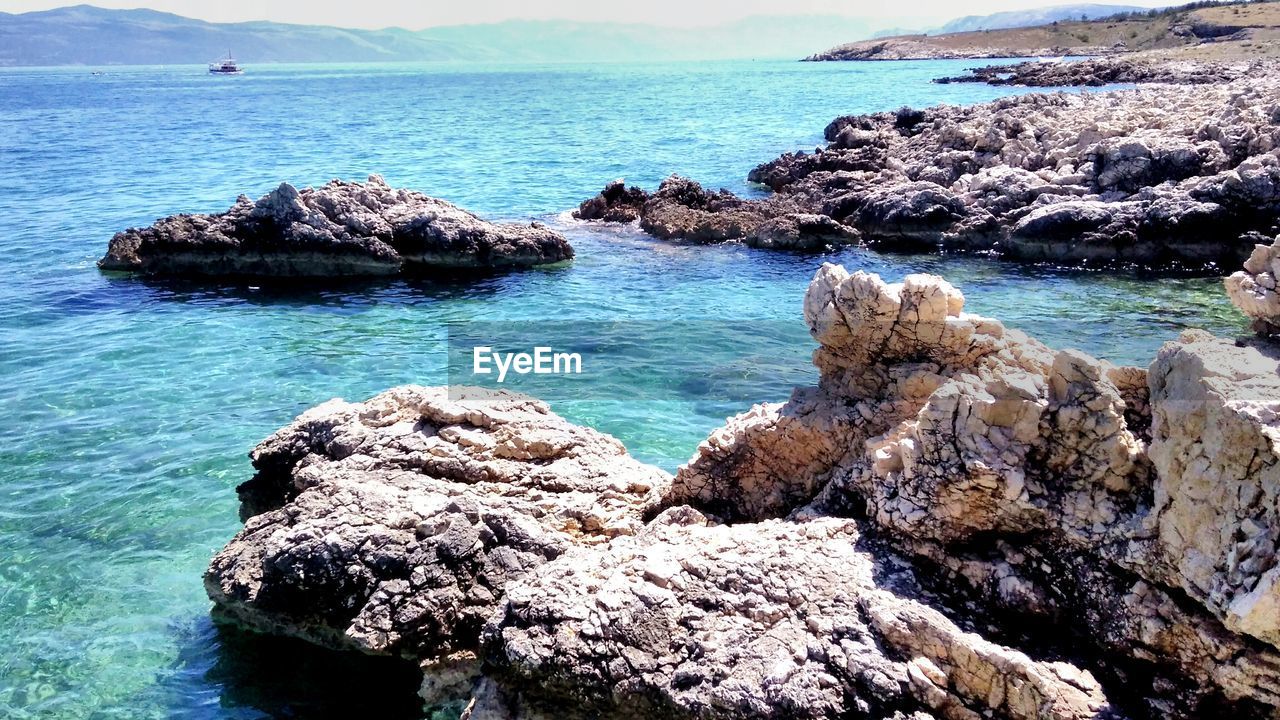 Rock formation in sea against sky