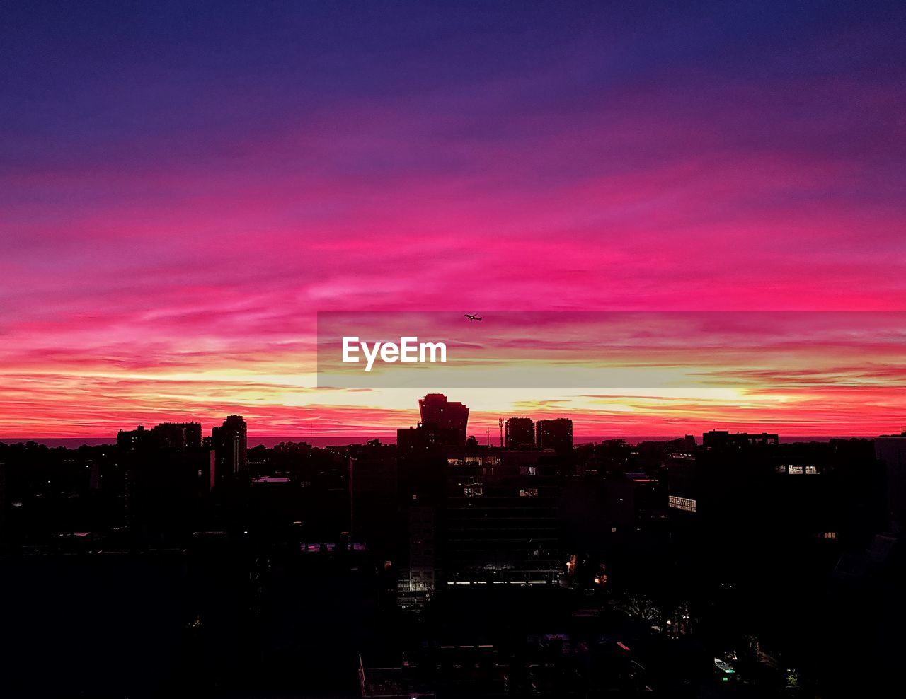 SILHOUETTE BUILDINGS AGAINST ORANGE SKY