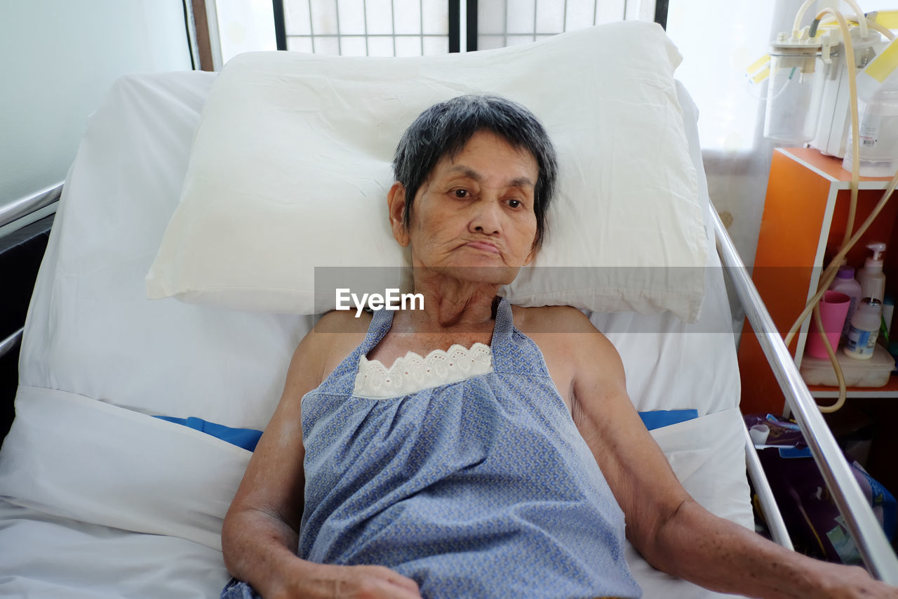 Senior woman relaxing on bed at hospital