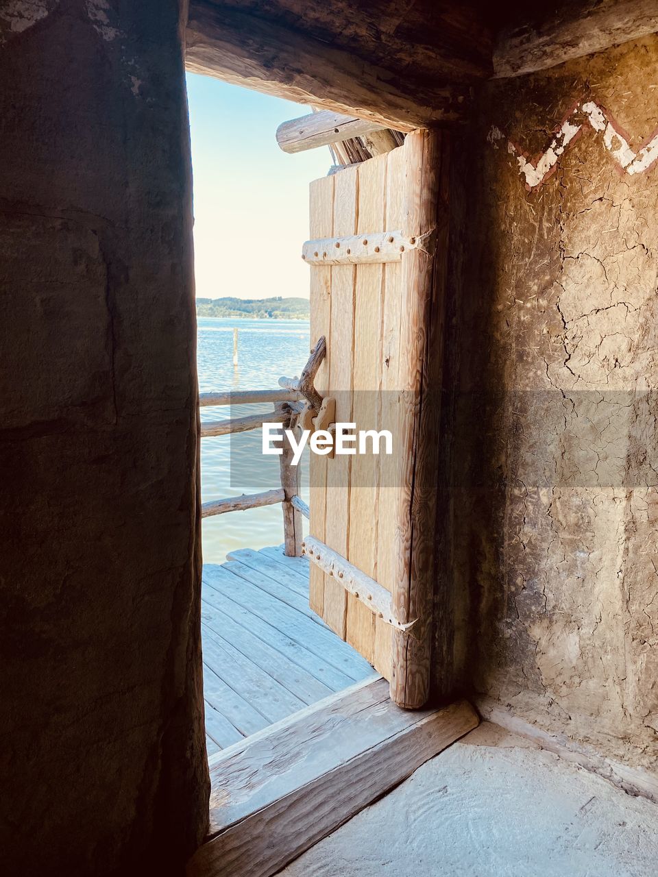 water, architecture, wood, sea, wall, nature, built structure, day, sunlight, travel, house, travel destinations, land, beach, vacation, trip, outdoors, no people, holiday, building, door, tourism, sky, entrance, tranquility, building exterior, blue, history