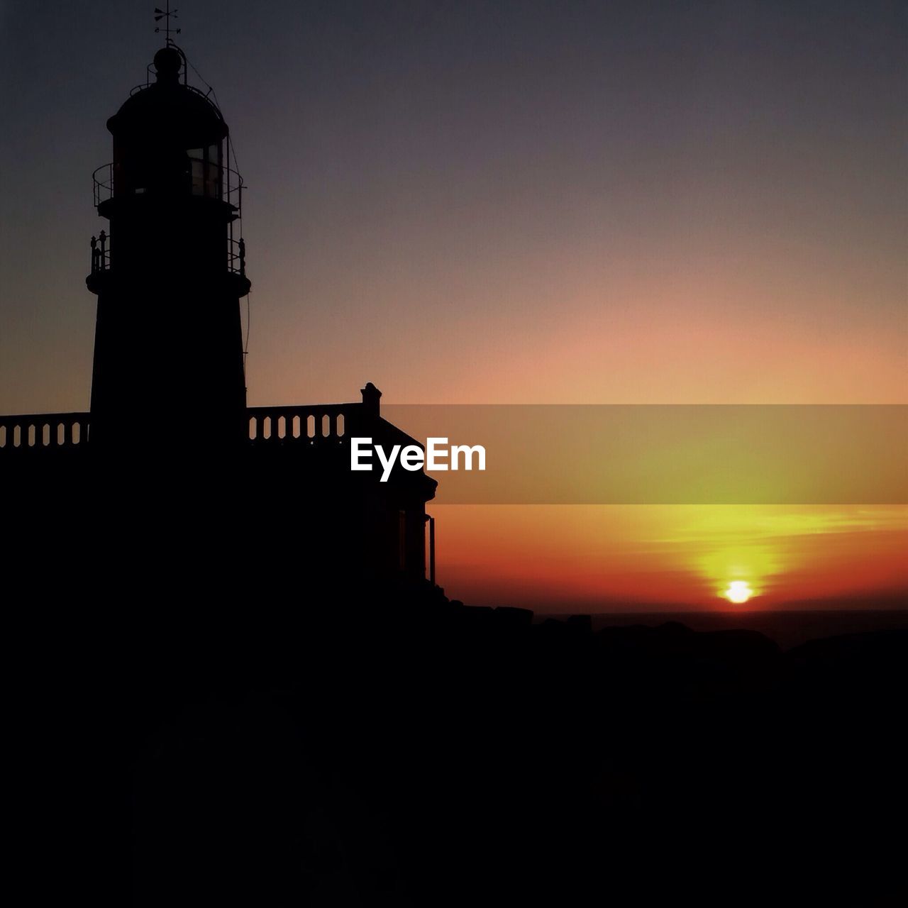 Low angle view of silhouette lighthouse against sky during sunset