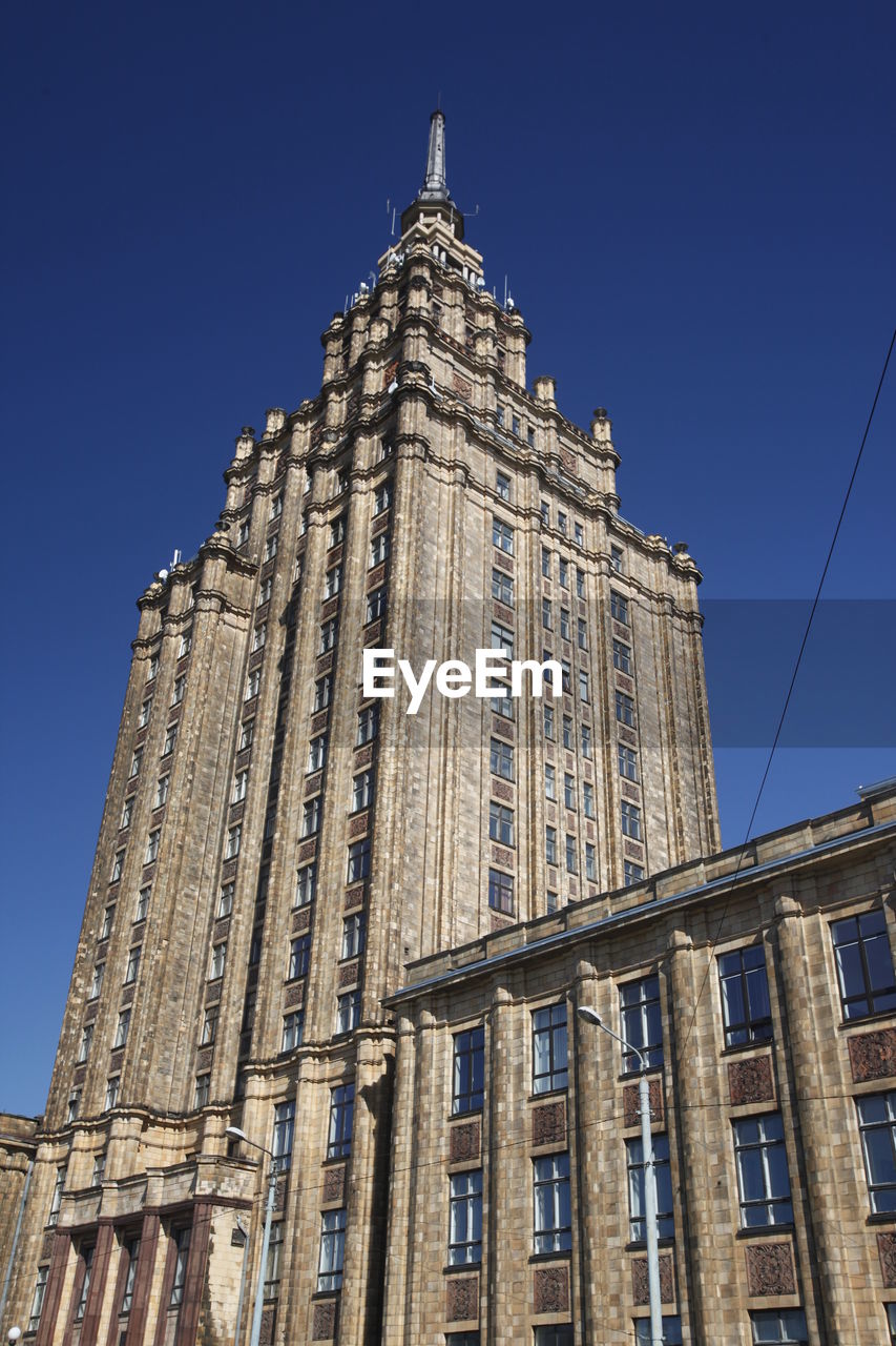 Low angle view of latvian academy of sciences against clear blue sky