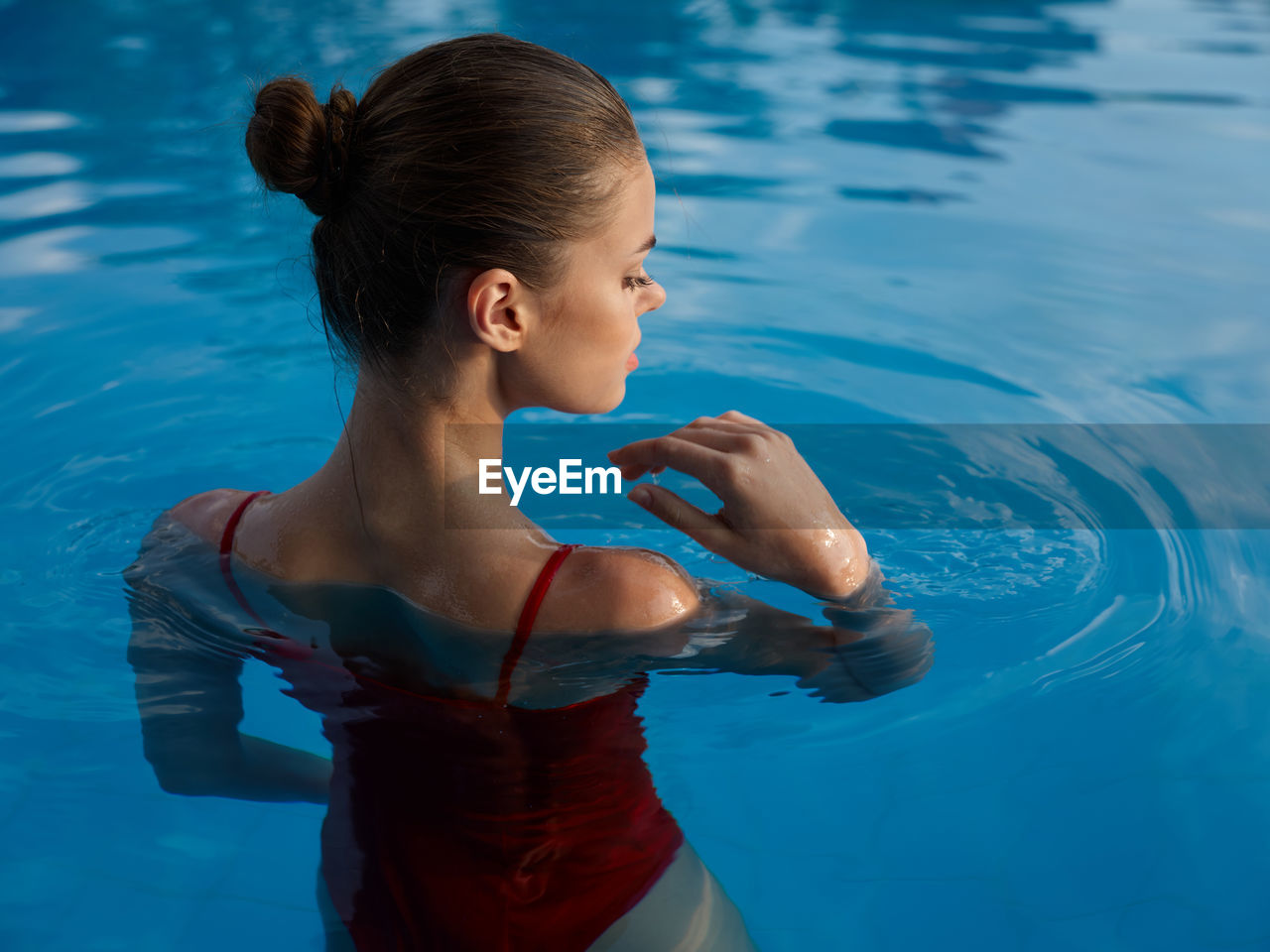 Rear view of woman standing in swimming pool