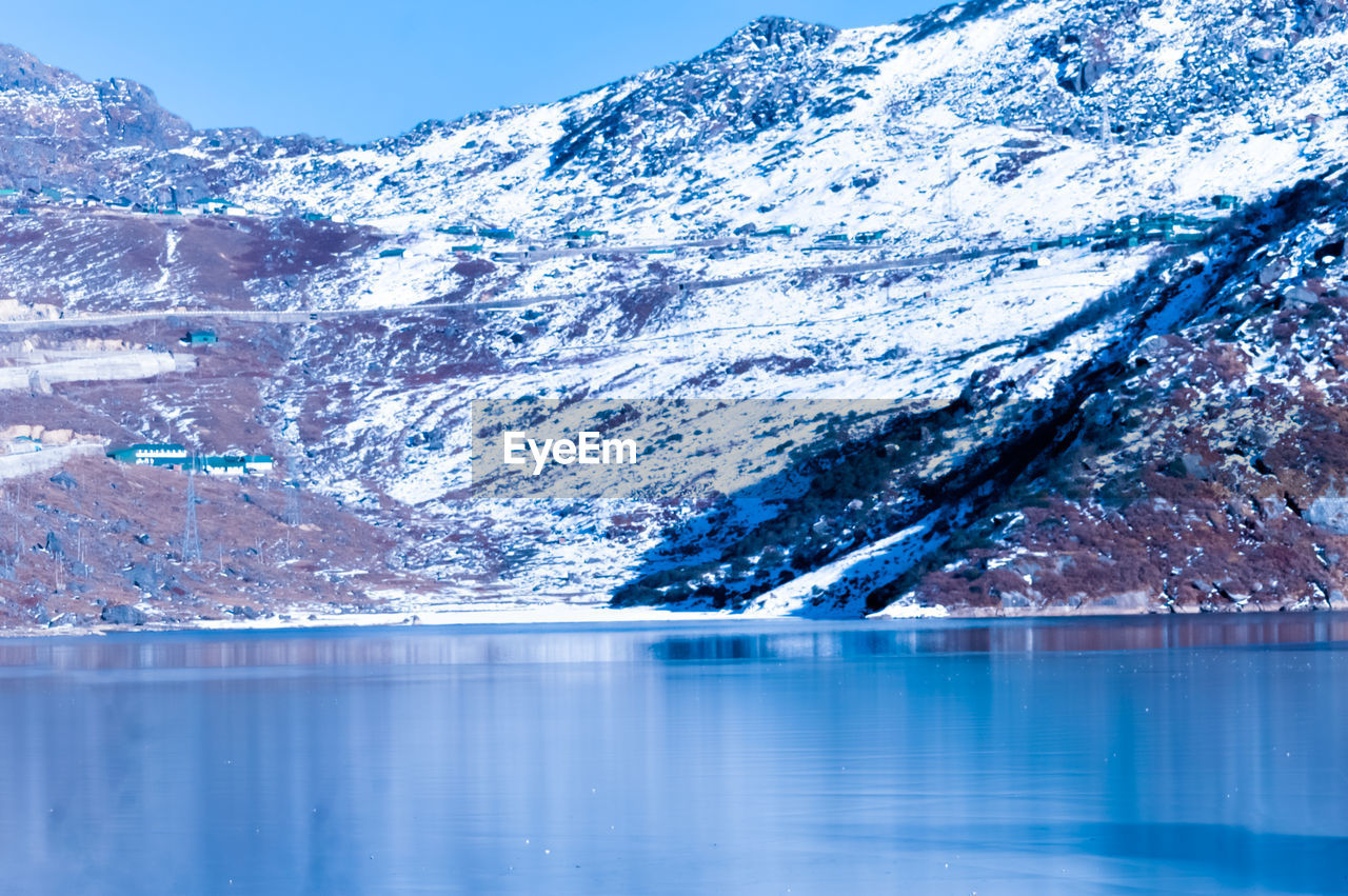 SCENIC VIEW OF LAKE AGAINST SNOWCAPPED MOUNTAINS