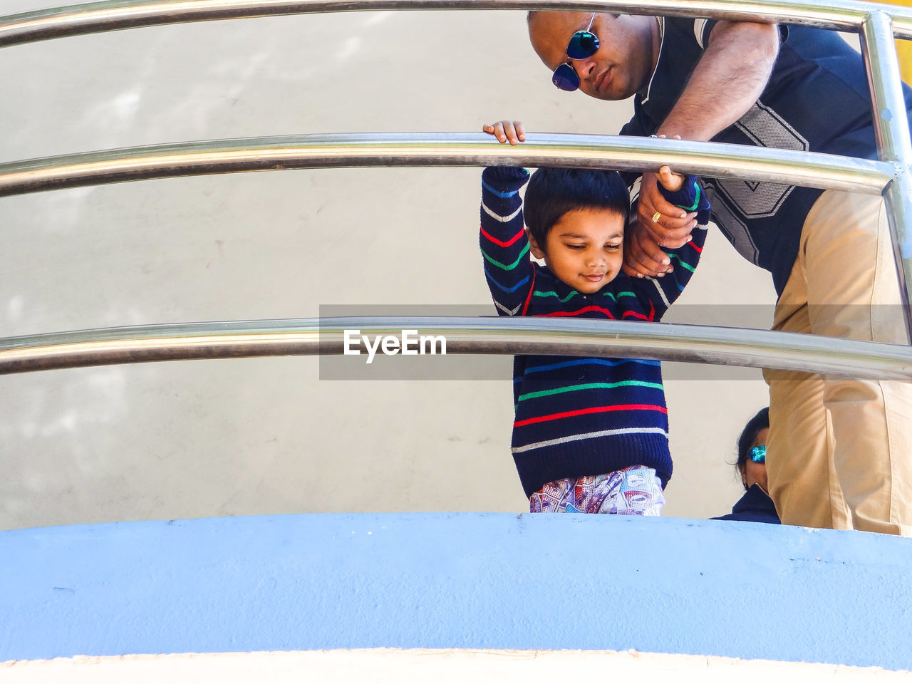 Father and son standing by railing