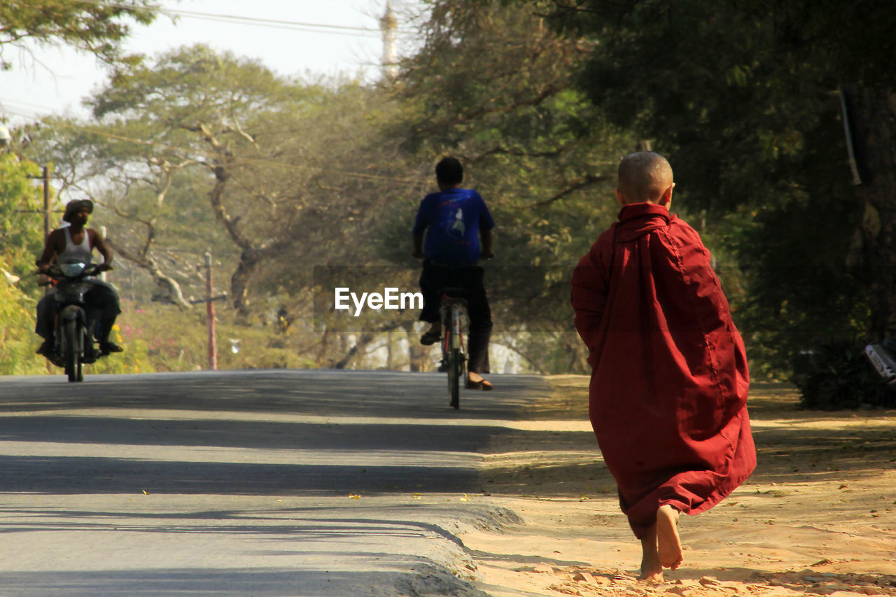 Rear view of monk walking on footpath