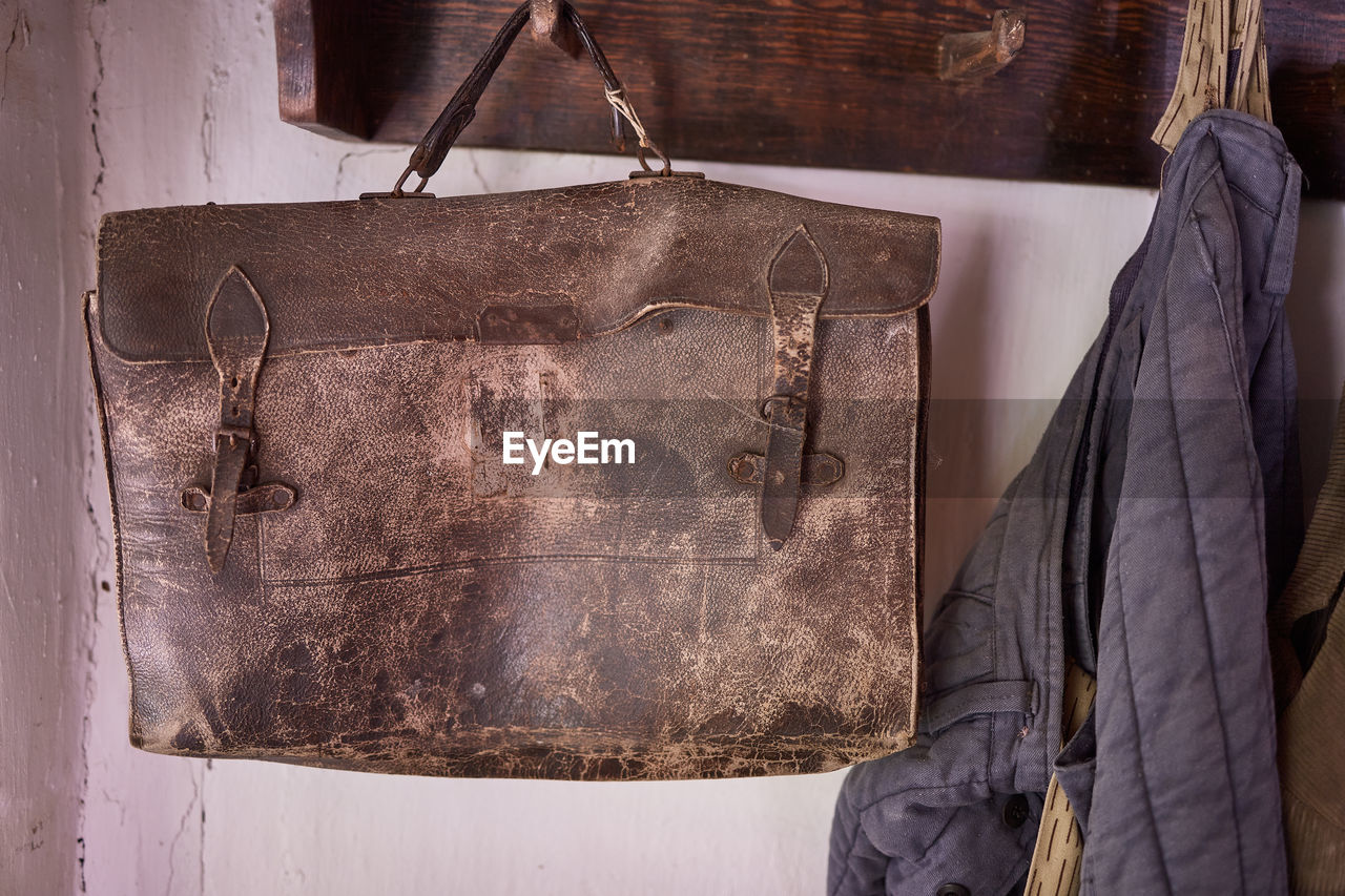 An old travel bag and jacket hanging on a hanger