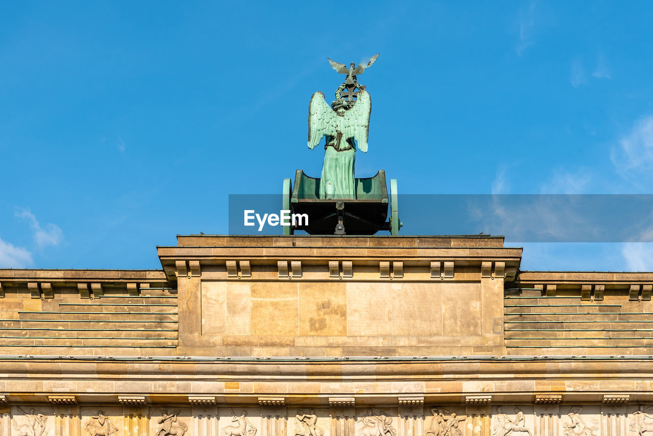 Low angle view of statue on building against sky