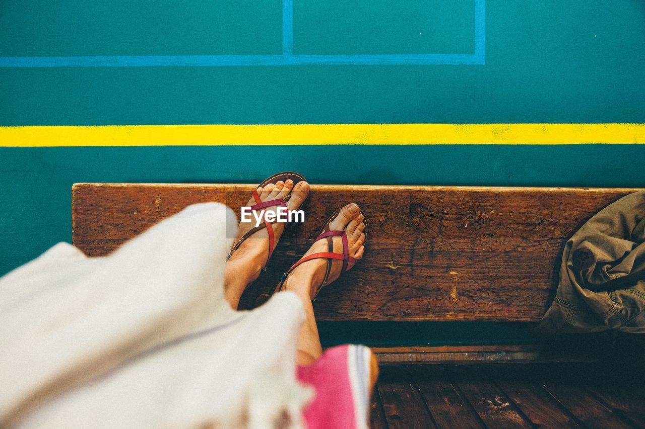 Low section of woman standing on wooden bench