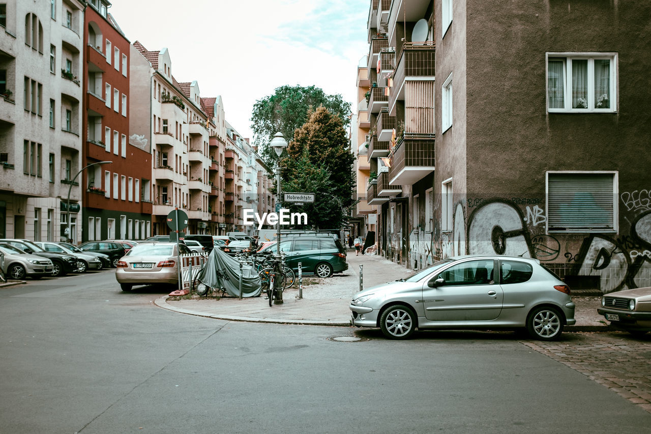 Cars parked by street amidst buildings