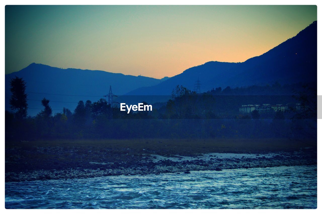 SCENIC VIEW OF MOUNTAINS AGAINST CLEAR SKY DURING SUNSET