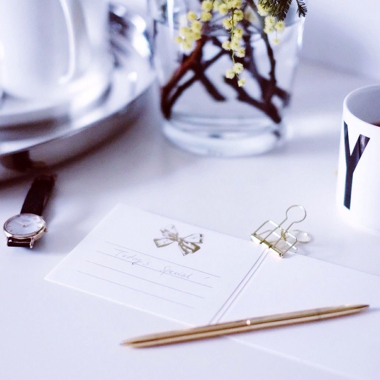 High angle view of pen with postcard and wristwatch on table