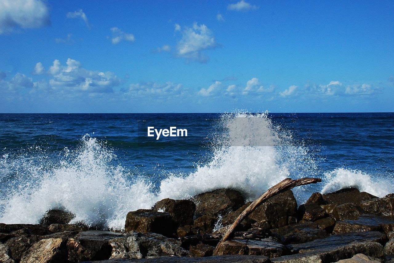 WAVES SPLASHING ON ROCKS AGAINST SEA