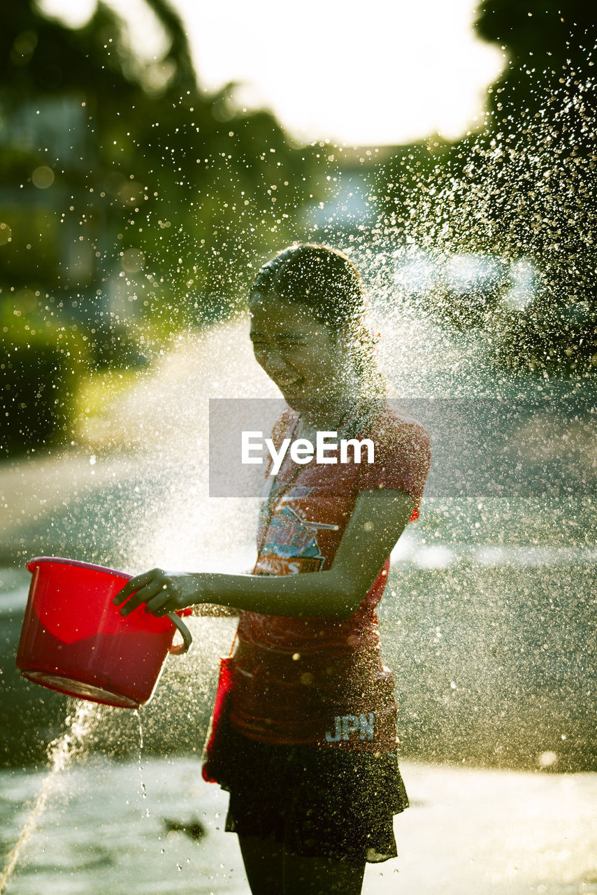 Water spraying on smiling girl