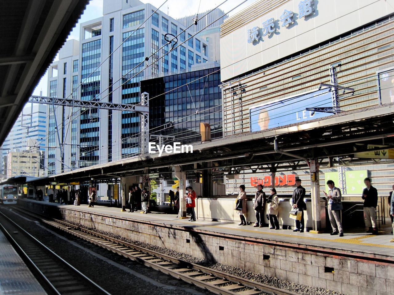 PEOPLE ON RAILROAD TRACK IN CITY