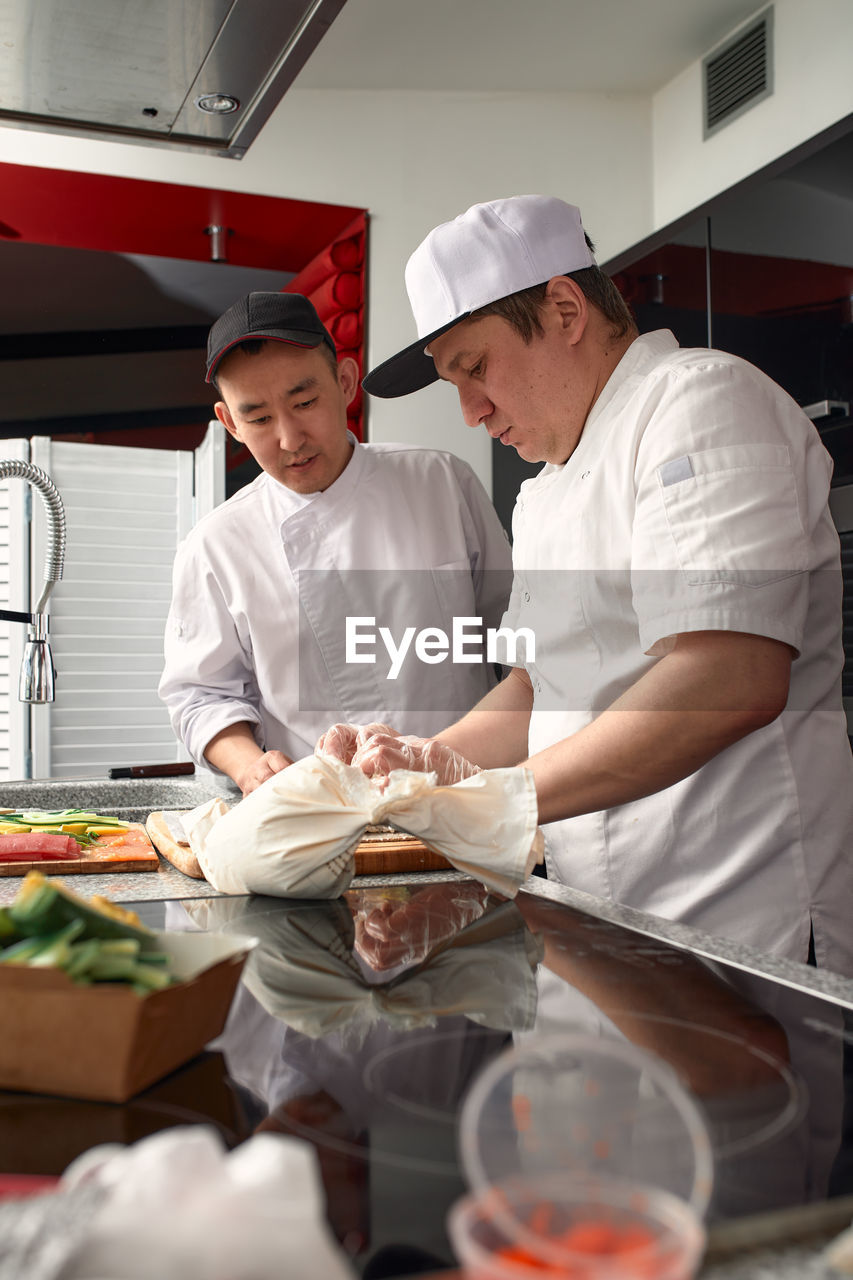 side view of man preparing food on table