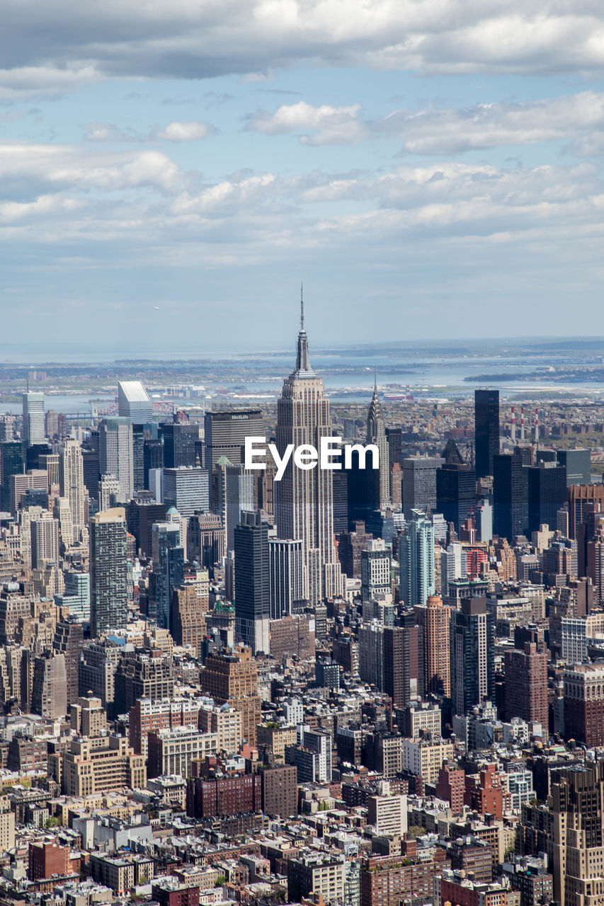 Empire state building amidst cityscape against sky at manhattan