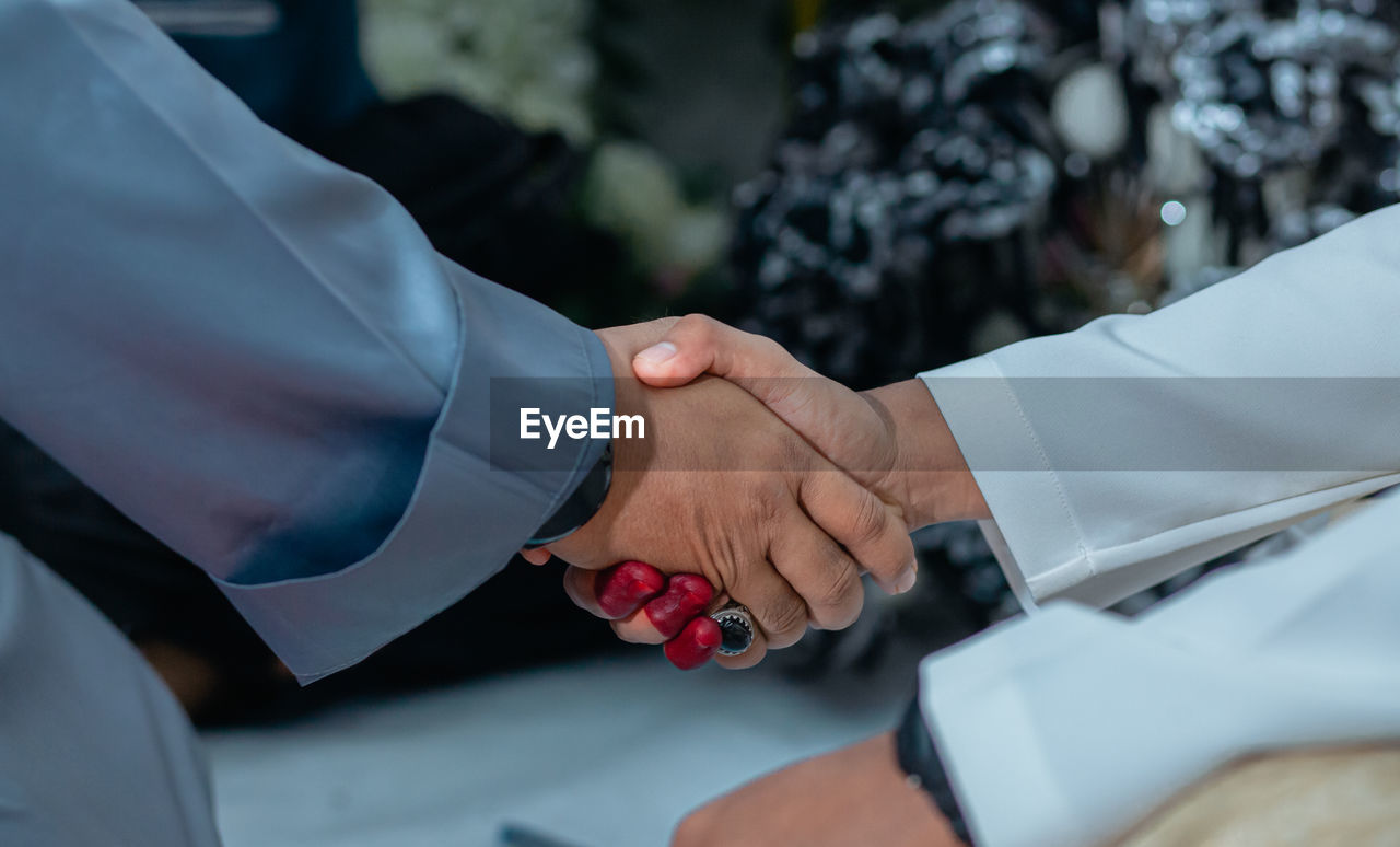 Midsection of doctor giving handshake