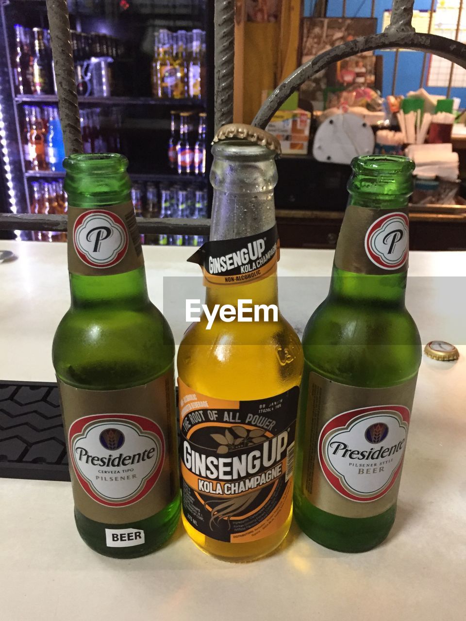 CLOSE-UP OF BEER BOTTLE ON TABLE