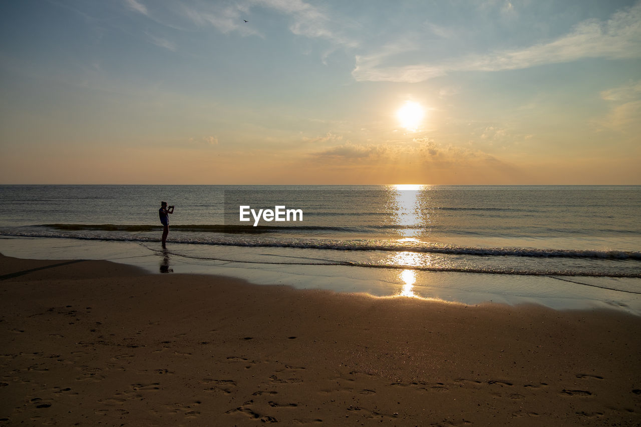 SCENIC VIEW OF BEACH DURING SUNSET