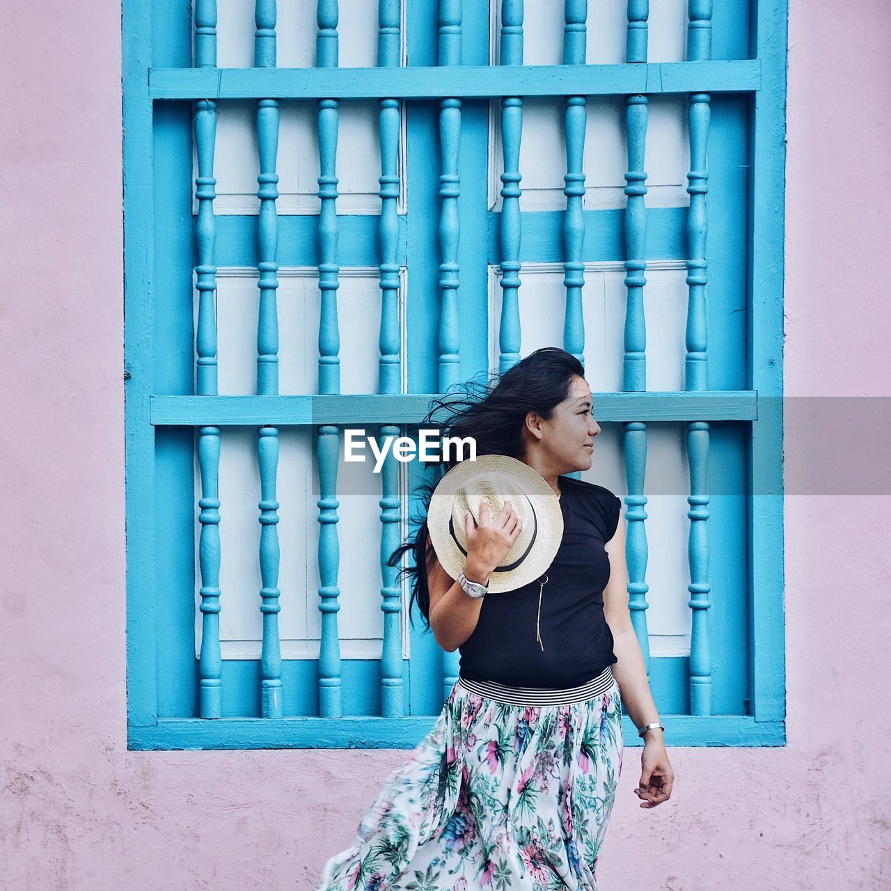 Young woman standing against wall