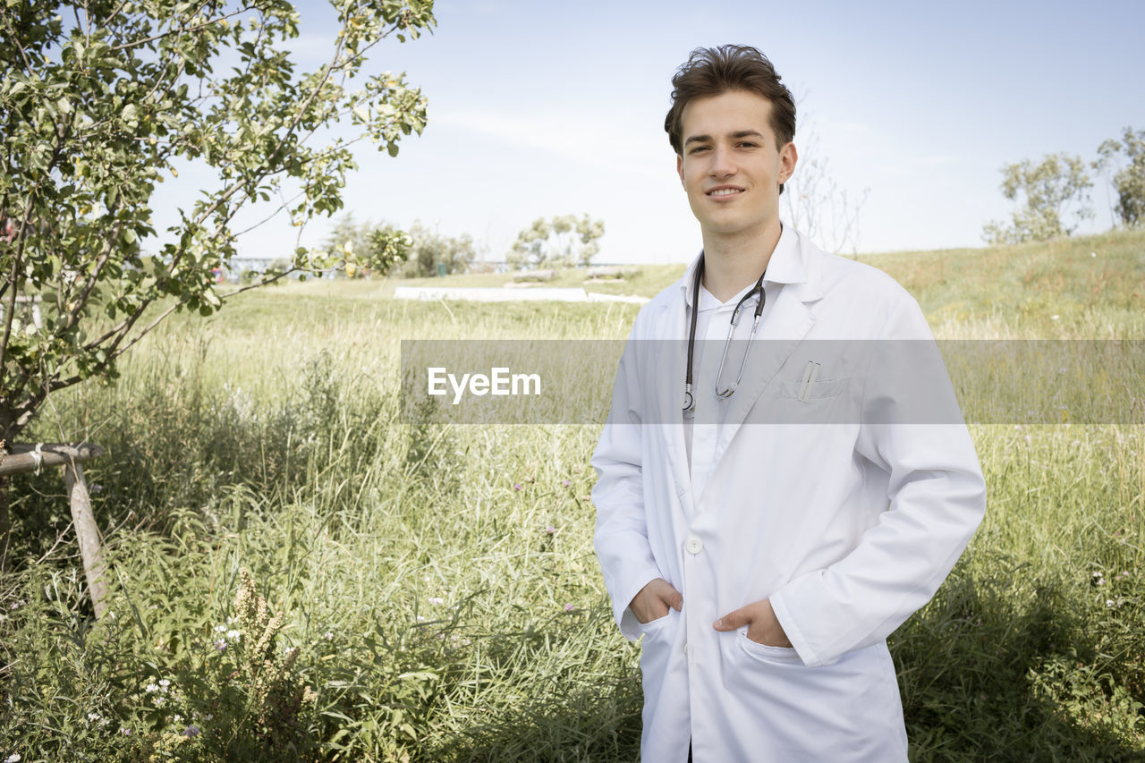 portrait of smiling female doctor standing in farm