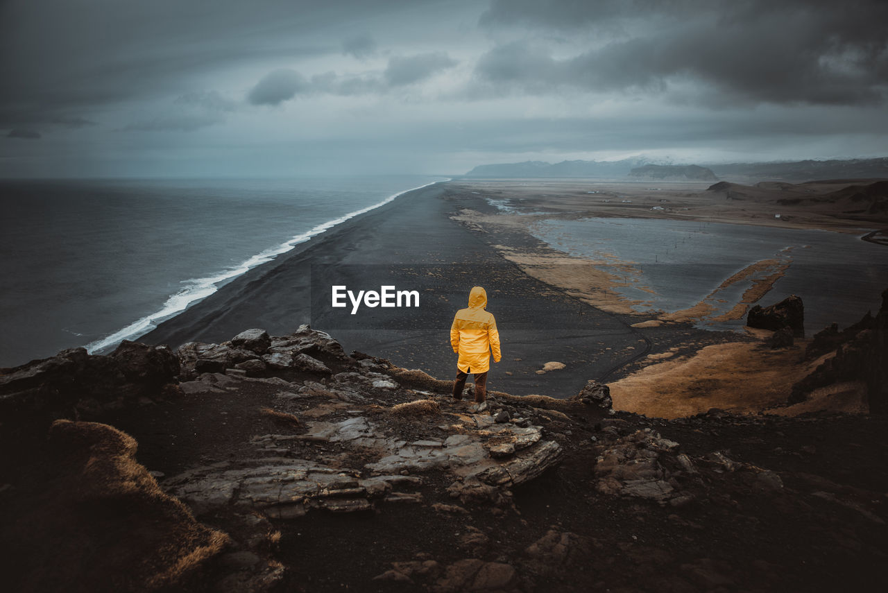 Rear view of man looking at sea against sky